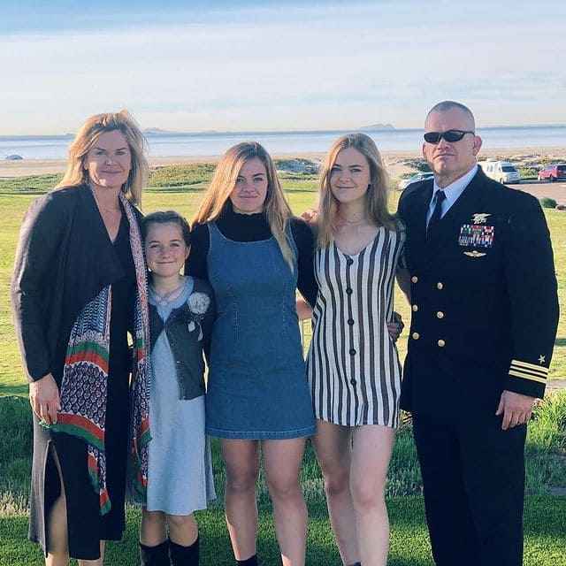 Jocko Willink in a navy uniform with his three daughters and wife.